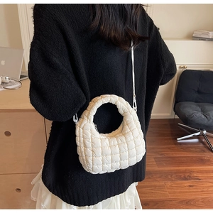 Close-up of beige quilted cloud bag with diamond stitching and elegant crossbody strap