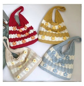 Flat lay of colorful knit tote bags with floral accents in red, yellow, beige and blue