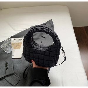 Detail of black quilted cloud bag with padded texture and adjustable shoulder strap