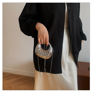 Close-up of metallic silver crescent bag with embossed texture and metal chain strap