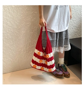 Close-up of handmade woven tote bag featuring red stripes and 3D daisy flower details