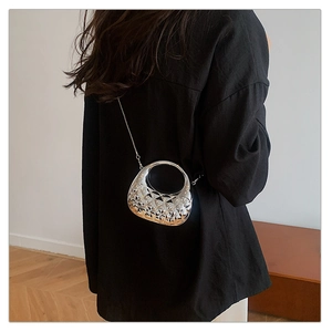 Detail of silver hollowed geometric pattern on mini chain bag with metallic handle