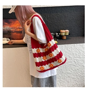 Close-up of red and white striped crochet shoulder bag with 3D orange knit flower details