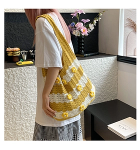 Macro detail of yellow and white striped crochet tote bag with 3D floral accents