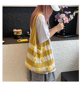 Close-up of knit tote bag with 3D yellow flowers and wavy crochet texture detail