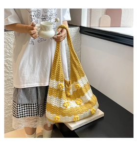 Detail of hand-woven tote bag with 3D yellow floral accents and striped knit texture