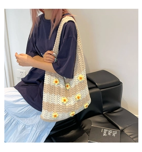 Detail of hand-crocheted tote bag with white stripes and 3D floral accents