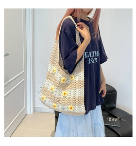 Detail of hand-woven tote bag with 3D crochet daisies and striped knit texture