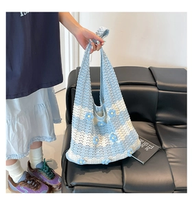Detail of handmade crochet tote bag featuring blue floral motifs and checkerboard pattern