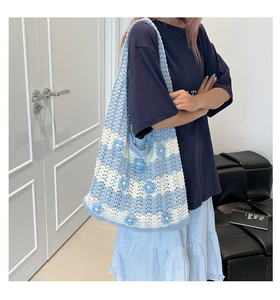 Detail of blue and white striped knit tote bag with handmade floral embroidery accents