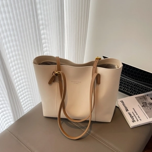 Minimalist beige tote bag with brown straps and spacious interior for daily commute