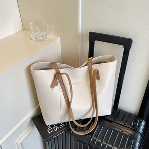 Chic beige leather tote bag with brown straps on luggage for stylish daily travel commuting