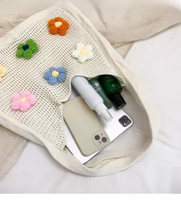 Detail view of large knit tote bag capacity showing floral patterns and daily essentials