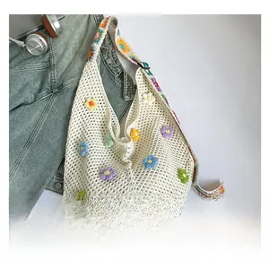 Detail der handgefertigten Häkeltasche mit bunten 3D-Blumen und gewebtem Schultergurt