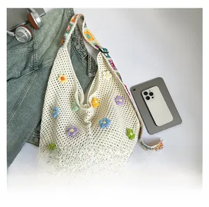 Detail der weißen Häkeltasche mit bunten 3D-Strickblumen und breitem Schultergurt