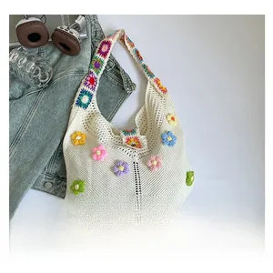 Close-up of white crochet tote bag with colorful 3D flower appliqués and hollow knit design
