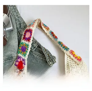 Detailed close-up of colorful floral crochet shoulder strap on cream woven tote bag