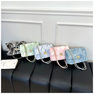 Détail de cinq sacs bandoulière en denim avec chaînes dorées et fermoirs métalliques