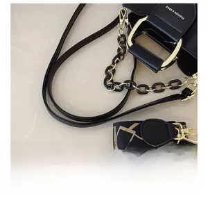 Detail view of black leather bag featuring golden hardware and adjustable jacquard wide strap