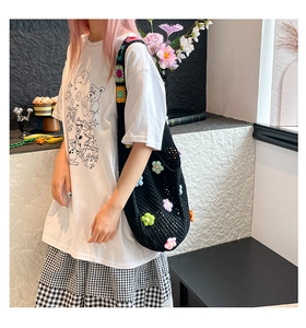 Detail der handgefertigten schwarzen Häkeltasche mit bunten 3D-Blumenakzenten