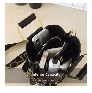 Detail view of spacious internal capacity in black crossbody bag with wide shoulder strap