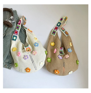 Detail view of crochet flower tote bags with 3D floral accents and granny square straps