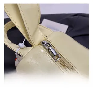 Detail shot of a cream PU leather handbag with high-quality zipper and stitching