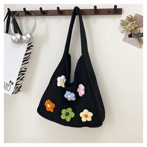 Close-up of black crochet shoulder bag featuring colorful handmade 3D floral accents