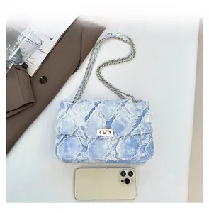 Comparaison de taille du sac en jean bleu matelassé à côté d'un smartphone