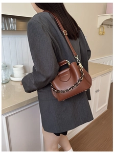 Brown leather bucket bag with tortoiseshell chain and adjustable gold hardware strap