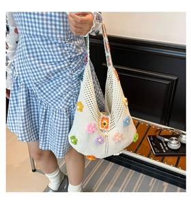 Detail of white crochet tote bag with colorful 3D floral accents and hollow knit pattern
