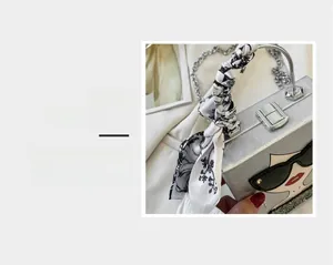 Silver square evening bag detail with pop art portrait and floral silk scarf handle