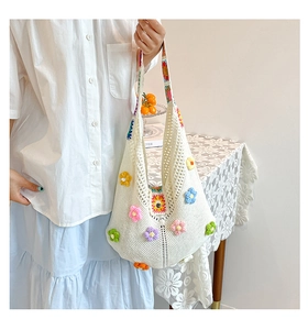 Detail of white crochet tote bag with colorful 3D flowers and ethnic pattern shoulder strap