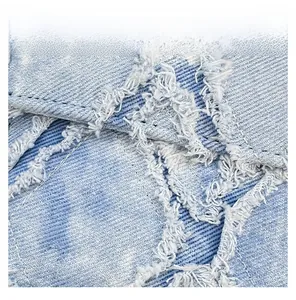 Gros plan sur le tissu denim bleu clair avec texture sergée et bords à franges