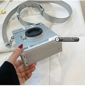 Detailed bottom view of camera shaped bag with metal rivets and premium stitched texture