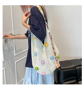 Detail der handgefertigten Häkeltasche mit bunten 3D-Blumen und gewebtem Gurt
