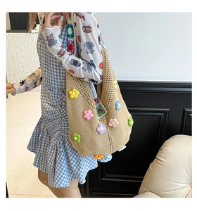 Detailed view of handmade woven tote bag with colorful 3D crochet flower decorations