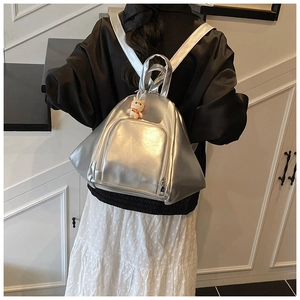 Detail of silver metallic backpack with zipper pocket and cute orange cat doll charm