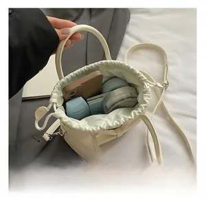 Top view showing internal capacity of the white leather drawstring bucket bag with essentials