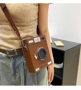 Close-up of retro camera-shaped crossbody bag with creative stitching and brown PU leather