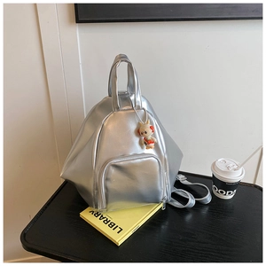 Detail of silver metallic backpack with geometric structure and cute rabbit charm