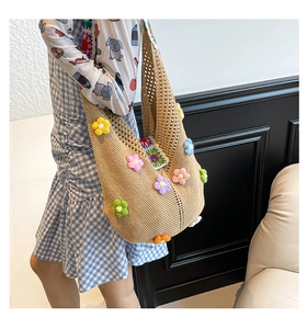 Close-up of handmade crochet tote bag featuring 3D floral accents and hollow knit texture