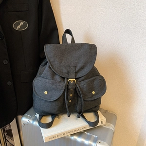 Dark grey denim backpack with retro buckles and dual pockets on a minimalist background