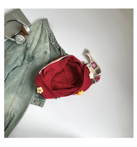 Detail der roten handgehäkelten Tasche mit 3D-Blumen und gemustertem Webriemen