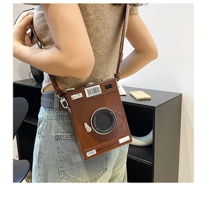 Detail of vintage camera crossbody bag with textured leather and simulation lens decoration