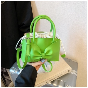 Green mini bow handbag with heart charm and drawstring inner bag for crossbody wear