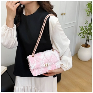 Détail du sac à chaîne en tweed rose et blanc avec fermoir doré et bandoulière tissée