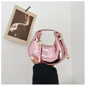 Macro view of a mini crescent moon handbag in pink metallic mirror finish texture