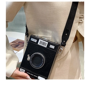 Detail of vintage camera shaped shoulder bag with textured faux leather and adjustable strap
