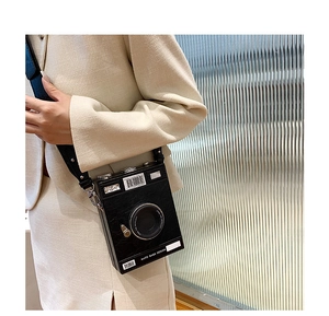 Detail view of the black retro camera bag with embossed leather texture and wide strap
